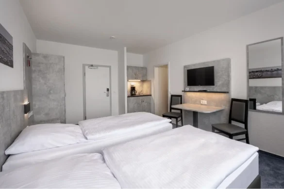 Helles Zweibettzimmer Standard mit Mikro-Küche, Fernseher und zwei getrennten Betten – perfekt für Kurzreisen.